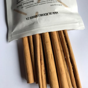 May include: A close-up of a bundle of cinnamon sticks. The sticks are brown and have a rough texture. They are arranged in a fan shape. The text "WWW.BLACKHILLWOODS.CA" is visible on the white packaging.