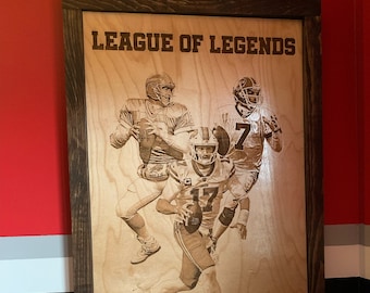 May include: A framed wood plaque with the text "League of Legends" and images of football players. The plaque also features the text "Buffalo Bills" and a buffalo silhouette.