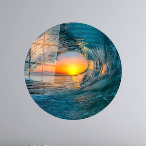 May include: A circular wall art piece featuring a photograph of a wave breaking, with the setting sun visible through the crest of the wave.