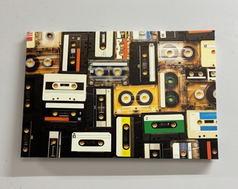 May include: A collage of vintage audio cassette tapes in various colors and designs. The tapes are arranged in a random pattern, creating a visually interesting and nostalgic image.
