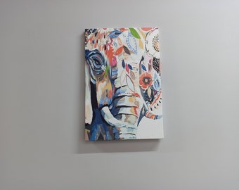 Puede incluir: Una pintura colorida de la cara de un elefante con patrones florales en tonos de azul, rojo, naranja y amarillo.