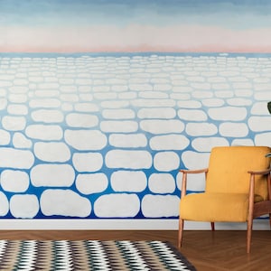 May include: A room featuring a mural with a blue and white stone pattern, a yellow chair, a potted plant, and a patterned rug. The mural depicts a gradient of blue and white shapes, resembling a stone wall.