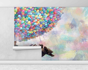 May include: A colorful illustration of a house being lifted into the air by hundreds of balloons. The house is attached to a bunch of colorful balloons, and the background is a watercolor wash of pink, blue, and yellow.