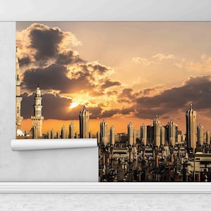 May include: A wallpaper roll partially unrolled, revealing a cityscape with tall buildings and minarets under a sunset sky. The buildings are in shades of gold and brown, with a dramatic sky of orange and gray clouds.