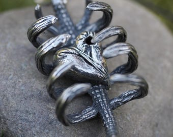 Unieke ketting met een hartvormige hanger in de vorm van een ribbenkast, perfect voor gothic- en horrorfans – een ideaal cadeau in buitenaardse stijl.