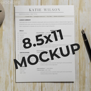 May include: A white resume mockup on a woodgrain surface with a black pen. The resume is 8.5x11 inches and has the text "Katie Wilson" at the top. The text "MOCKUP" is in large black letters over the resume.