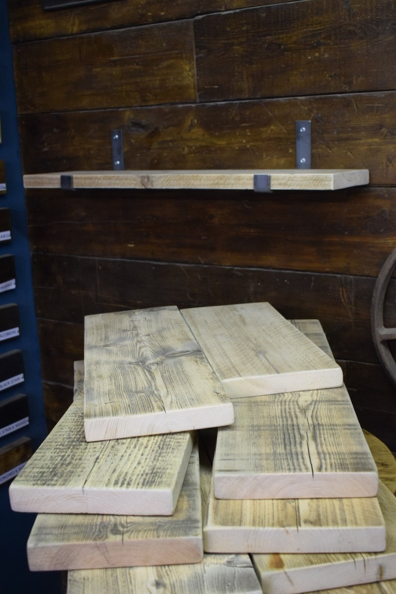 Op de afbeelding: Een stapel gerecyclede houten planken met een natuurlijke afwerking. De planken zijn gemaakt van ruw gezaagd hout met knoesten en nerven. De planken zijn op elkaar gestapeld, wat een rustieke en industri&euml;le uitstraling geeft.