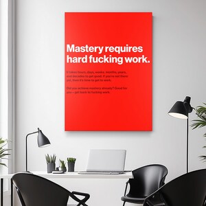 Puede incluir: Un lienzo rojo con texto blanco que dice "Mastery requires hard fucking work." Texto adicional debajo indica el tiempo que se tarda en lograr el dominio. La impresi&oacute;n se muestra en un entorno de oficina moderno.