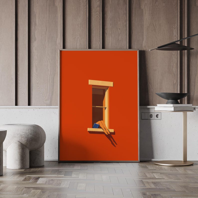 May include: A framed art print featuring a minimalist illustration. The artwork depicts a person relaxing in a window, with legs and feet visible. The background is a vibrant orange, with a wooden window frame. The artwork is displayed on a wall.