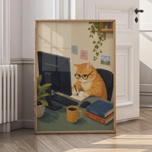 Op de afbeelding: Een ingelijste print met een oranje tabby kat met een bril die aan een computer werkt. De kat zit aan een bureau met een koffiemok, boeken en een notitieblok. De print heeft een houten frame en wordt getoond in een kamer met een witte deur.