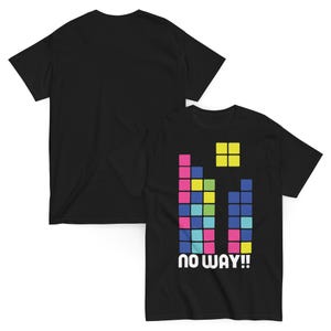 May include: A black short-sleeve t-shirt featuring a graphic of colorful square blocks arranged in vertical columns, resembling a falling puzzle game. Below the blocks, the text "NO WAY!!" is printed in a bold, white, sans-serif font.
