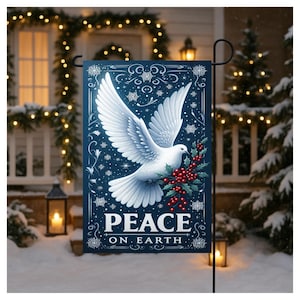 May include: A blue garden flag with a white dove carrying holly berries. The flag reads "PEACE ON EARTH" in white lettering. The background is a winter scene with snow and Christmas lights.