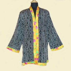 May include: Black and white patterned kimono with yellow and pink floral trim. The kimono has a long, open front and three-quarter sleeves.