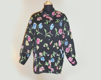 May include: A black long-sleeved button-up shirt with a floral print featuring pink, blue, and green flowers.