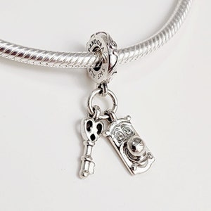 Peut inclure: Bracelet de charme en argent avec un charme en forme de clé et un charme en forme de marteau de porte. Le charme est gravé avec "Pandora" et "925 ALE".