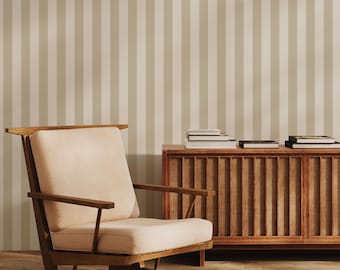 May include: A mid-century modern living room scene featuring a wooden armchair with a cream-colored cushion, a wooden cabinet, and a striped wallpaper background. Several books are stacked on the cabinet. The room has a warm, inviting atmosphere.