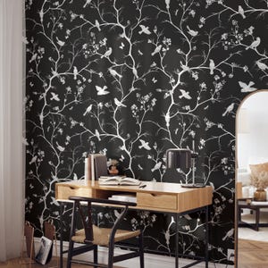 May include: A black and white wallpaper with a repeating pattern of branches and birds. The wallpaper is in a home office setting with a desk, chair, and lamp.