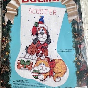 Puede incluir: Kit de punto de cruz Bucilla para un calcetín navideño con un perro y un gato. El calcetín tiene el nombre "SCOOTER" en letras rojas. El kit incluye un diseño de bloqueo diagonal de 25,4 cm.