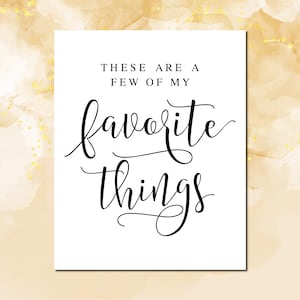 May include: A white printable sign with black calligraphy text that reads "These are a few of my favorite things."