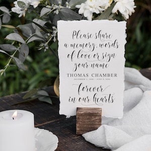 Puede incluir: Una tarjeta blanca con texto negro en un soporte de madera. El texto dice "Por favor, comparte un recuerdo, palabras de amor o firma tu nombre. Thomas Chamber 1 de diciembre de 1956 - 2 de junio de 2024 para siempre en nuestros corazones."