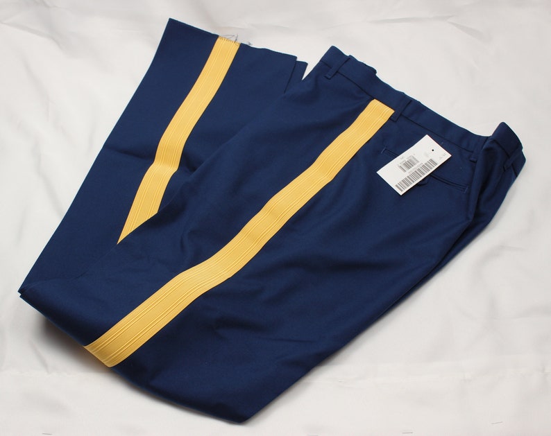 Puede incluir: Un pantal&oacute;n azul marino con rayas amarillas a los lados. El pantal&oacute;n tiene una etiqueta adjunta.