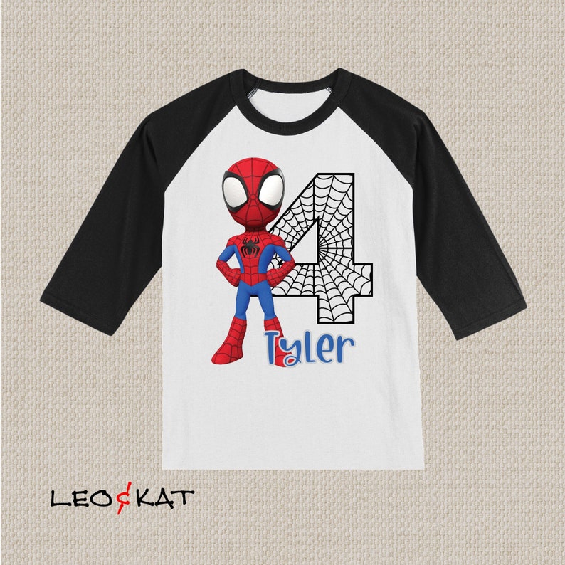May include: A white and black baseball tee shirt with a red and blue cartoon Spiderman character and a black and white spiderweb number 4. The name Tyler is written below the number.