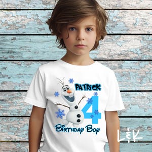 May include: White t-shirt featuring a cartoon snowman with the name "Patrick" and the number "4" in blue, along with the text "Birthday Boy". The design includes snowflakes.