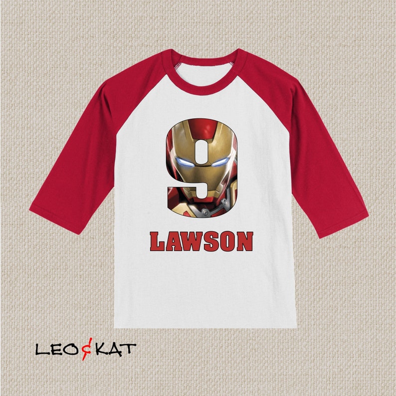 Pu&ograve; includere: Maglietta da baseball bianca e rossa con un numero nove rosso che presenta il viso di Iron Man. Il testo "LAWSON" &egrave; stampato sotto il numero.