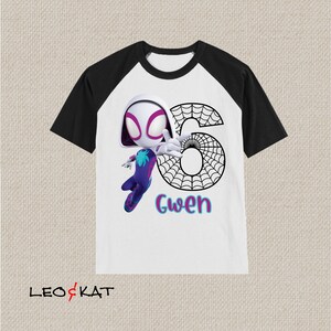 May include: White t-shirt with black raglan sleeves. It features a cartoon Spider-Gwen character, the number 6 in a spiderweb design, and the name "Gwen" in teal and pink. The shirt has the logo "LEO & KAT" at the bottom.