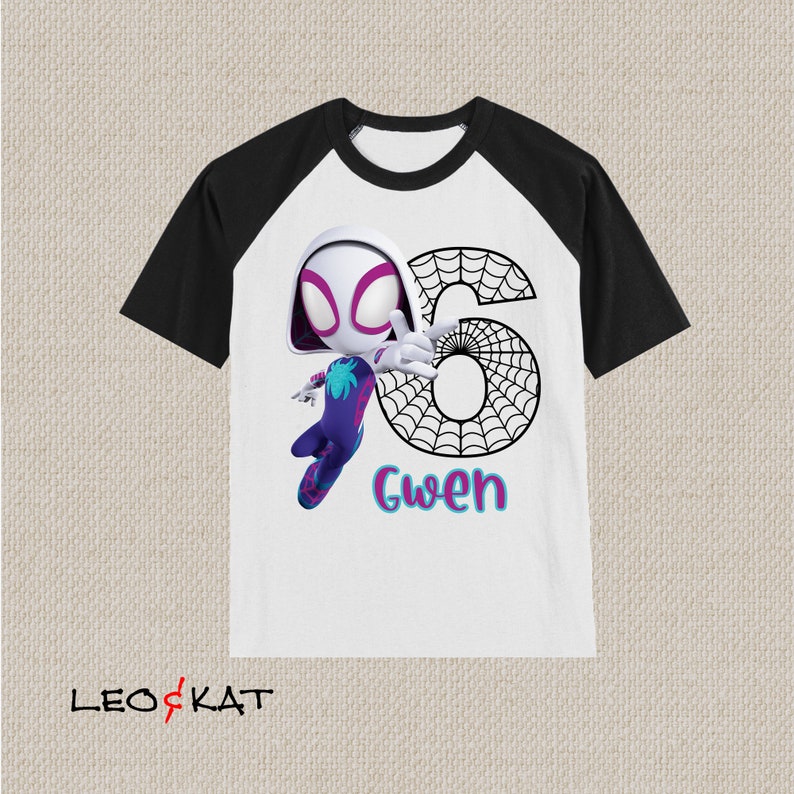 May include: White t-shirt with black raglan sleeves. It features a cartoon Spider-Gwen character, the number 6 in a spiderweb design, and the name "Gwen" in teal and pink. The shirt has the logo "LEO & KAT" at the bottom.