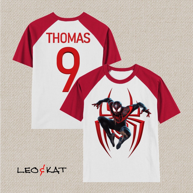 May include: White and red raglan t-shirt with a black and red Spiderman graphic on the front and the name "THOMAS" and the number "9" on the back.