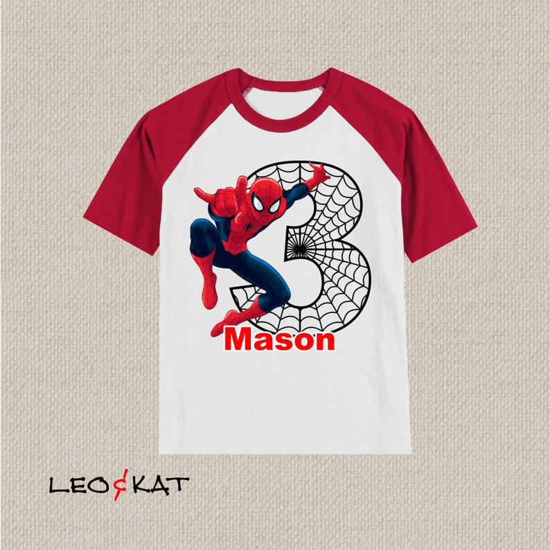 Puede incluir: Camiseta de manga raglan blanca y roja con un gr&aacute;fico de Spiderman y el n&uacute;mero 3. El gr&aacute;fico tambi&eacute;n incluye una telara&ntilde;a y el nombre "Mason".