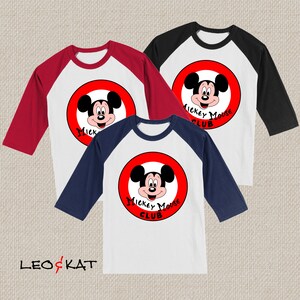 以下が含まれることがあります： 赤い円とミッキーマウスのグラフィックが描かれたベースボールTシャツが3枚。シャツは白で、赤と青の袖が付いています。シャツのテキストは「ミッキーマウスクラブ」です。