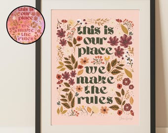May include: A pink floral print with the text "This is our place we make the rules" in dark green letters. The print is framed in a black frame.
