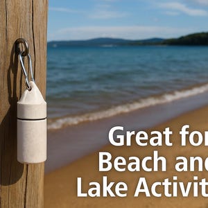 May include: A cylindrical, off-white, matte-finish waterproof container with a black O-ring seal, attached to a silver metal carabiner. The text "Great for Beach and Lake Activities" is displayed in white font on the right side of the image.
