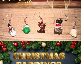 May include: A collection of Christmas-themed earrings. The earrings feature festive designs like a snowman, Grinch, reindeer, chimney, and Santa hat. The image also includes the text "CHRISTMAS EARRINGS" in gold lettering, surrounded by Christmas greenery.