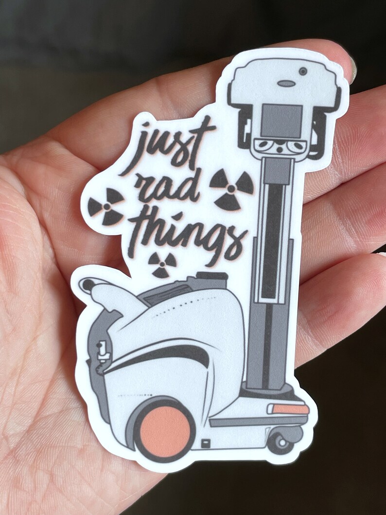 May include: White sticker with a black and white illustration of a robot with the text "just rad things" and a radioactive symbol.
