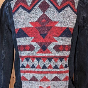 May include: A black denim jacket with a red, white, and blue geometric pattern on the back.