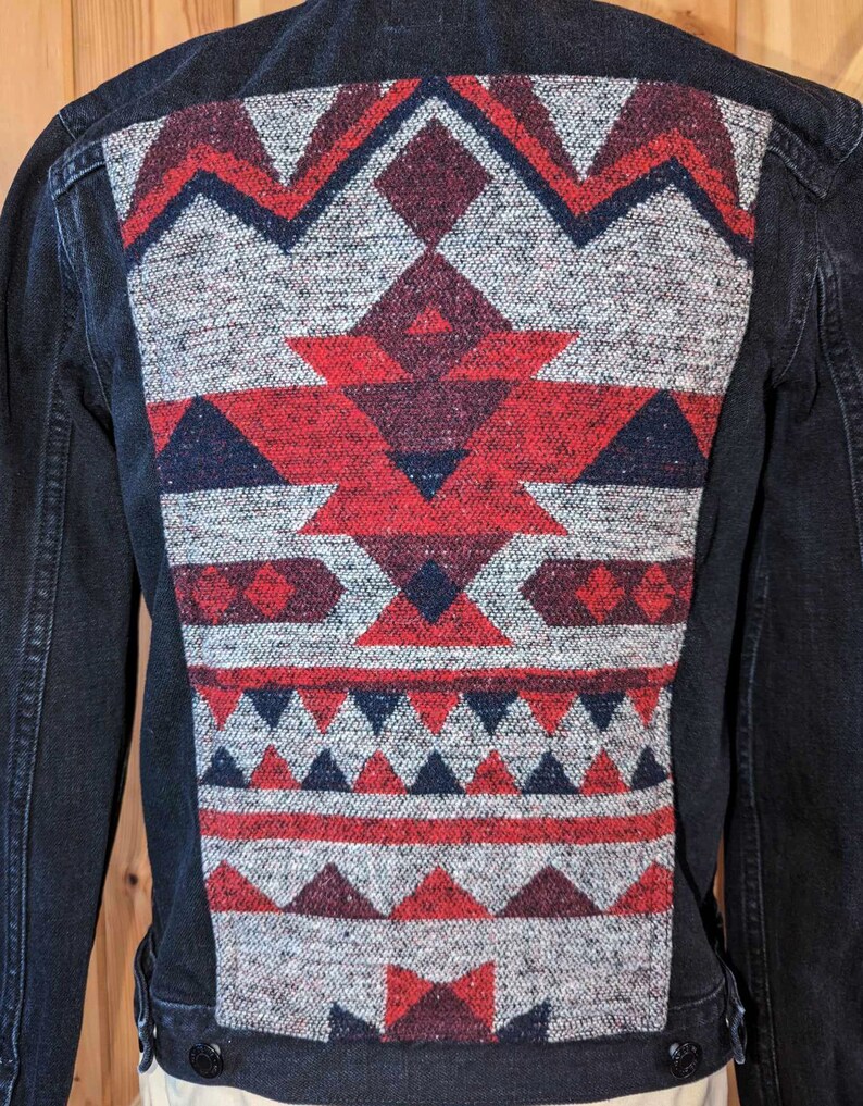 May include: A black denim jacket with a red, white, and blue geometric pattern on the back.