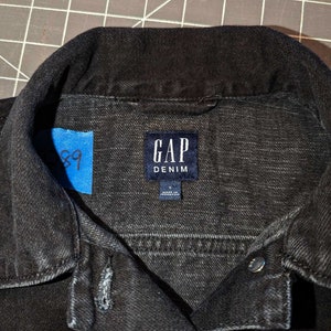May include: Black denim jacket with a label that reads "GAP DENIM" and "Made in Indonesia".