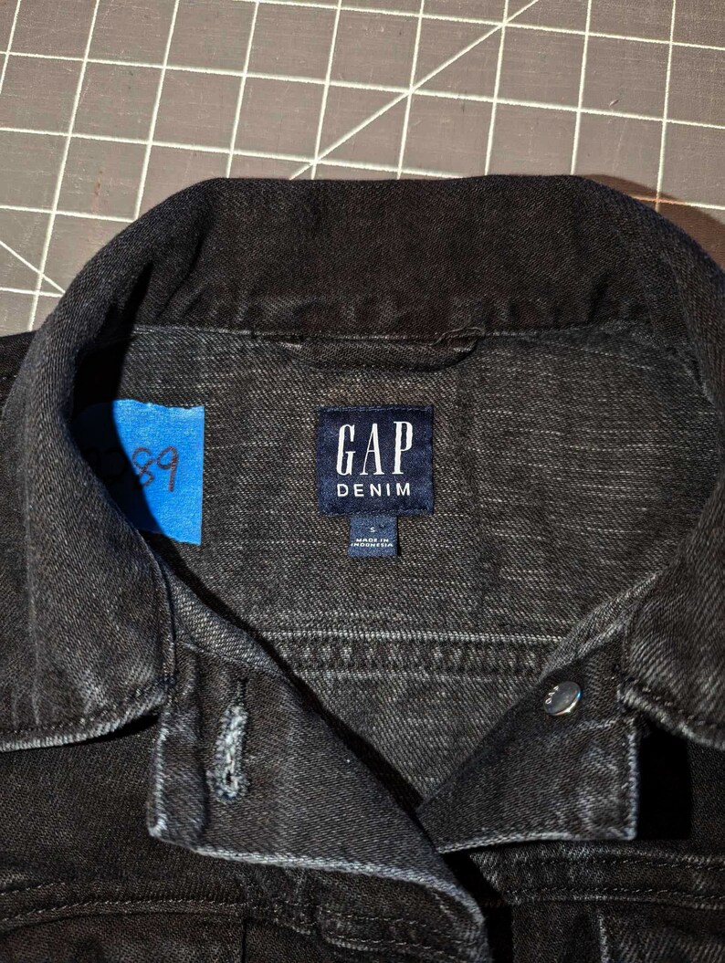 May include: Black denim jacket with a label that reads "GAP DENIM" and "Made in Indonesia".