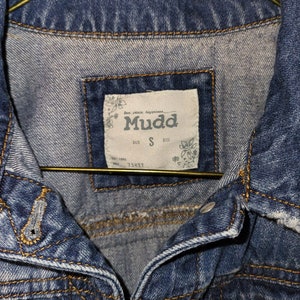May include: A blue denim jacket with a label that reads "Mudd" and "Size S".