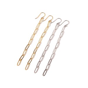 May include: A pair of long, dangling earrings with a chain link design. One pair is gold and the other is silver.