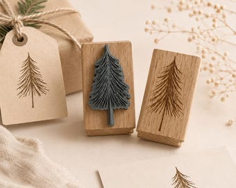 Pode incluir: Uma coleção de carimbos com tema natalino e embrulhos para presente. Os carimbos apresentam um design detalhado de pinheiro, um em cinza escuro e dois em marrom. Uma caixa de presente embrulhada em papel marrom com uma etiqueta e um raminho de vegetação também está presente.