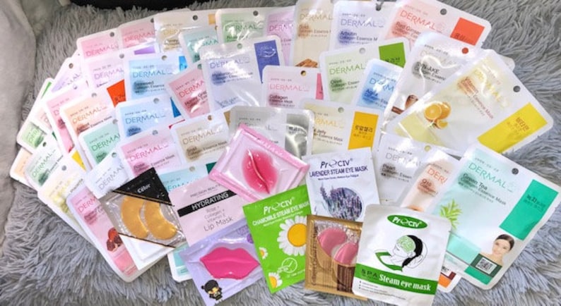 May include: An assortment of face masks and eye patches in various colours and designs. The masks feature different ingredients, including green tea, collagen, and lavender. The eye patches are gold, pink, and white.