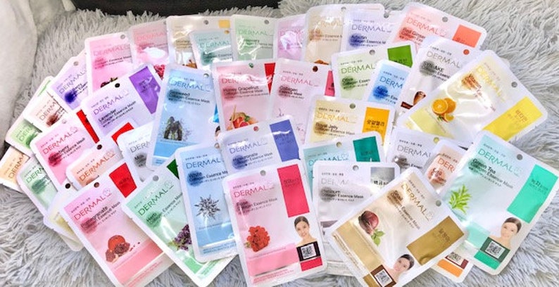 May include: A selection of face masks in individual packaging. The masks are white with colourful designs and text that reads "Dermal Essence Mask".