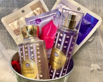 May include: A silver metal basket filled with bath and body products. The basket contains two bottles of whipped berry meringue body lotion, a bottle of whipped berry meringue body spray, and a pink face mask.