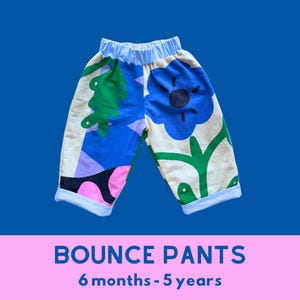 May include: Children's trousers with a blue elasticated waistband and cuffs. The design features a colourful floral and abstract pattern in blue, green, pink, and cream. The text "BOUNCE PANTS" and "6 months - 5 years" are displayed at the bottom.