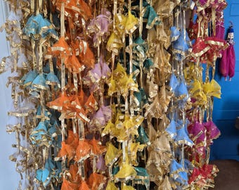 May include: A collection of colorful fabric garlands with gold trim. Each garland is made of multiple layers of sheer fabric, creating a delicate and airy look. The garlands are perfect for adding a touch of festive cheer to any occasion.