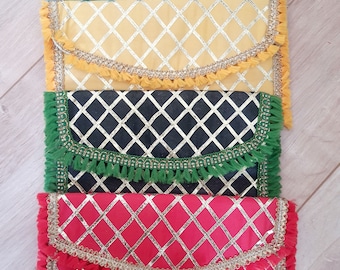 May include: Four decorative clutches with a diamond pattern and gold trim. The clutches are in the colors green, yellow, black, and red.
